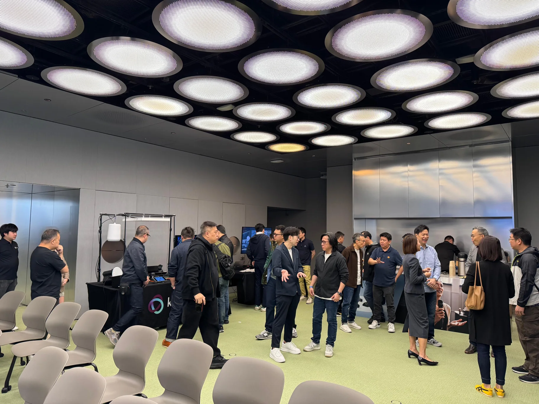 Roadshow attendees talking and networking beside the product demonstration area