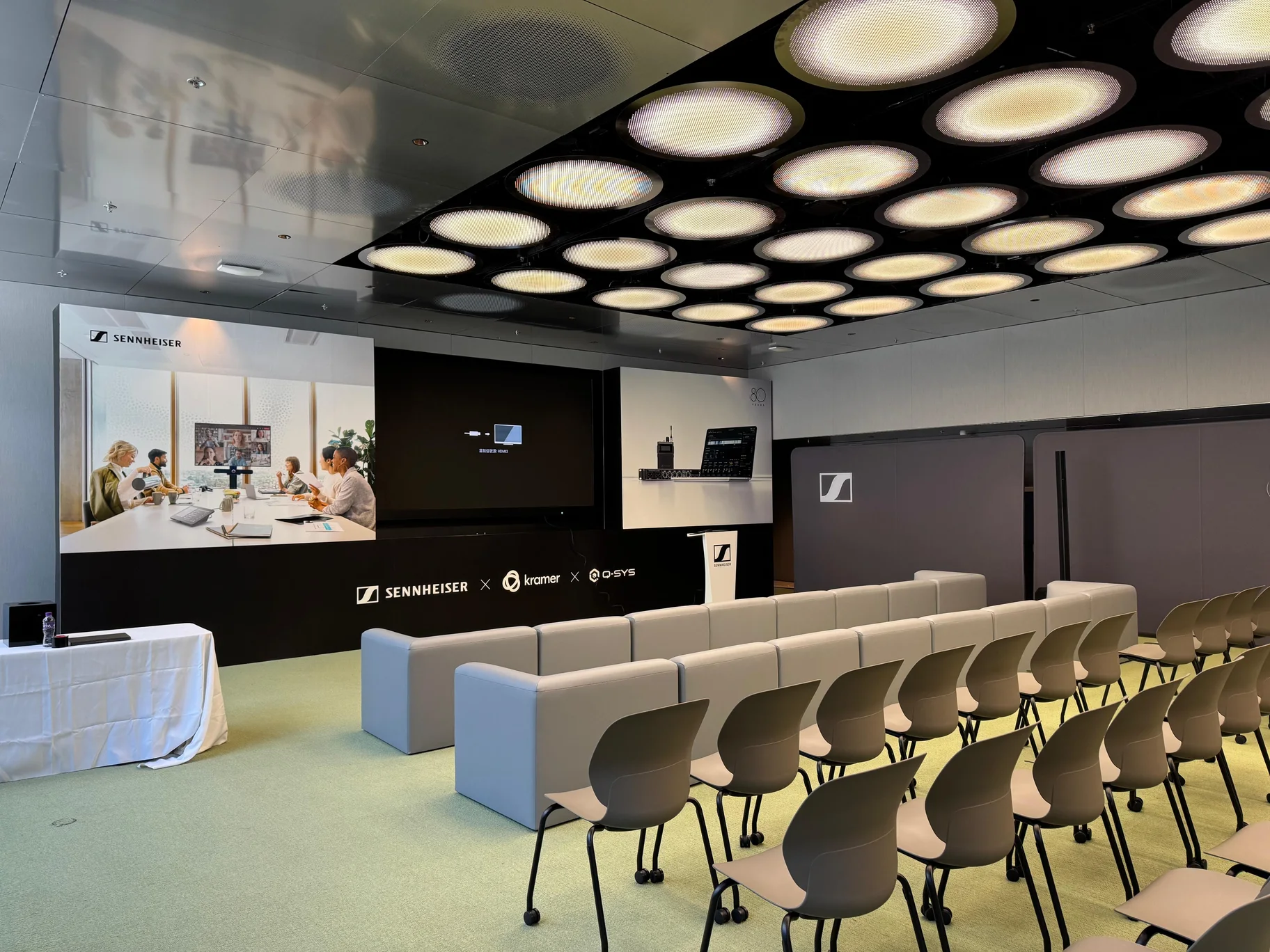 Branded Sennheiser presentation area with screen, lectern and seating